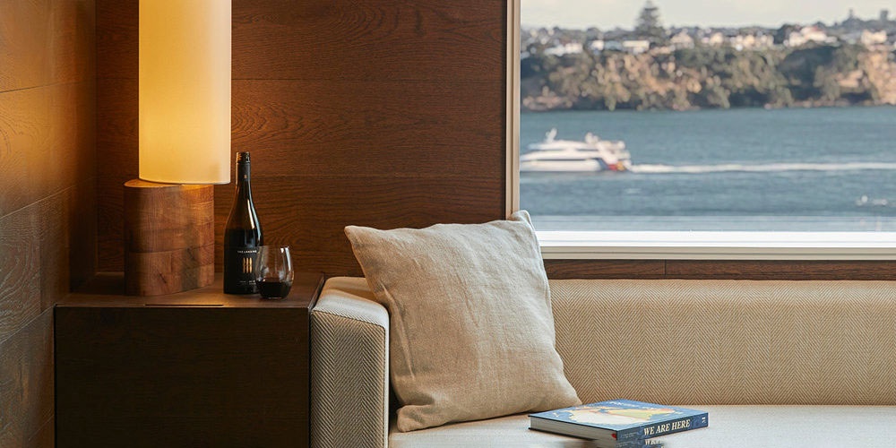 The Hotel Britomart A sofa inside a hotel room with a view out to the Waitemata Harbour