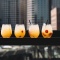 Cocktails on a leaner at a rooftop bar with high rise buildings in the background